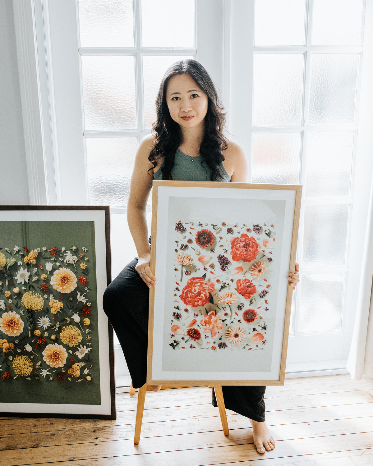 Portrait of floral art photographer Connie Chan with framed flower art prints