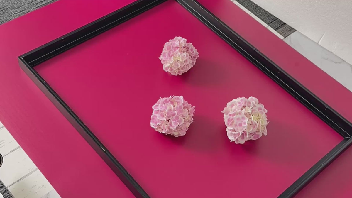 process of hand arranging a floral flatlay for a fine art photo shoot featuring pink hydrangeas